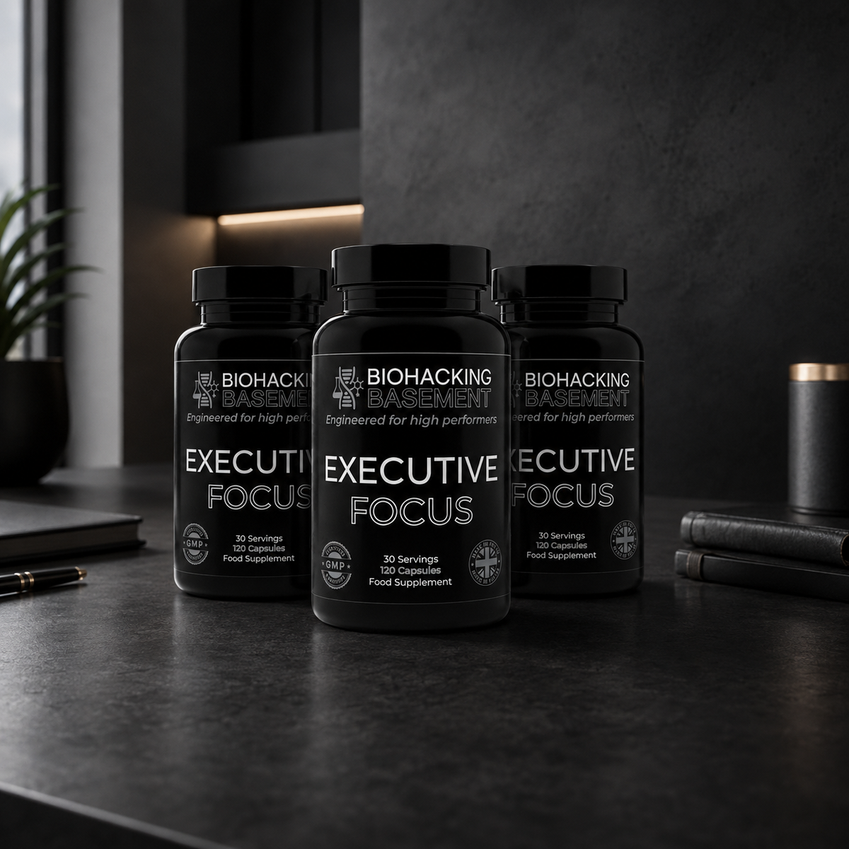 Three black supplement bottles labeled BIOHACKING BASEMENT Executive Focus are arranged on a dark countertop in a modern kitchen setting.